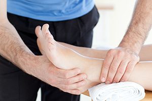 Idris is operformig a deep tissue massage treatment on a male foot in his Natural Moves Studio in Notting Hill, London W10